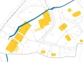 Extrait du cadastre de Lisieux, plan montrant des parcelles numérotées et des bâtiments en jaune, traversé par une rivière bleue.