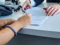 Signature d'un compromis de vente, remise en main propre du modèle.