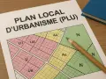 Plan local d'urbanisme (PLU) de Sète, avec un crayon posé sur la carte zonée.