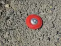 Borne rouge sur le sol, marquant un point pour le cadastre de Tarascon.