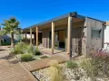 Une maison en bois moderne avec terrasse et jardin, une construction sans permis de construire idéale pour un espace de vie contemporain.