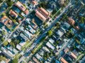 Vue aérienne d'un quartier résidentiel, avec des maisons aux toits de tuiles et des rues bordées d'arbres, rappelant l'application du l442-10 code urbanisme.