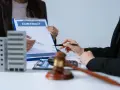 Deux mains signent un contrat immobilier, évoquant le droit de rétractation. Une maquette d'immeuble est visible.