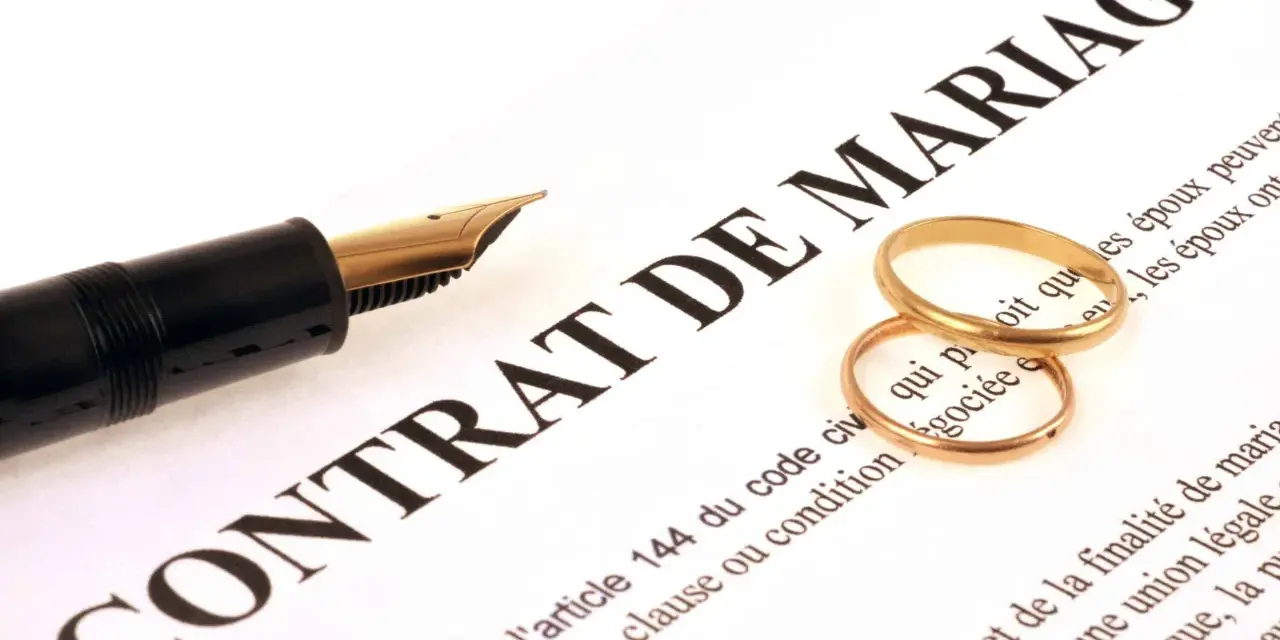 Plume et alliances sur un contrat de mariage, symbolisant une union et une récompense travaux d'amélioration.