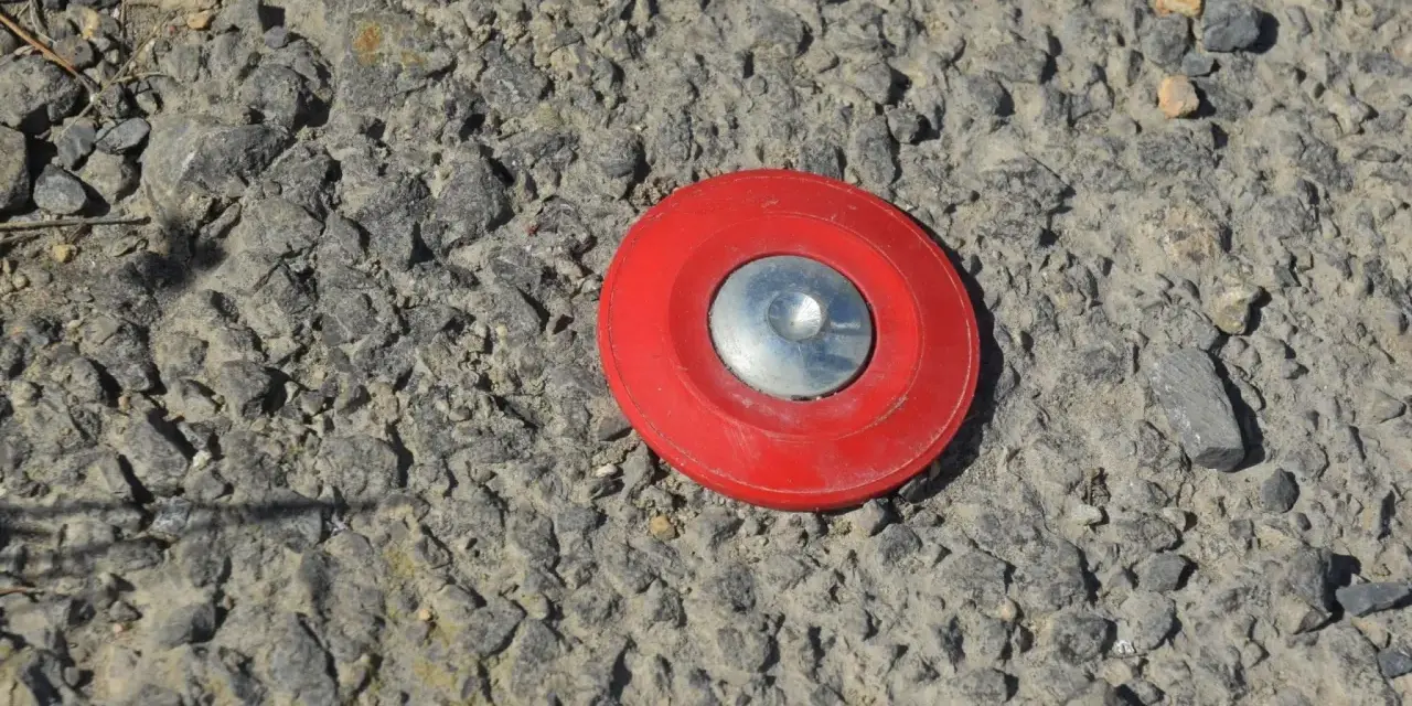 Borne rouge sur le sol, marquant un point pour le cadastre de Tarascon.