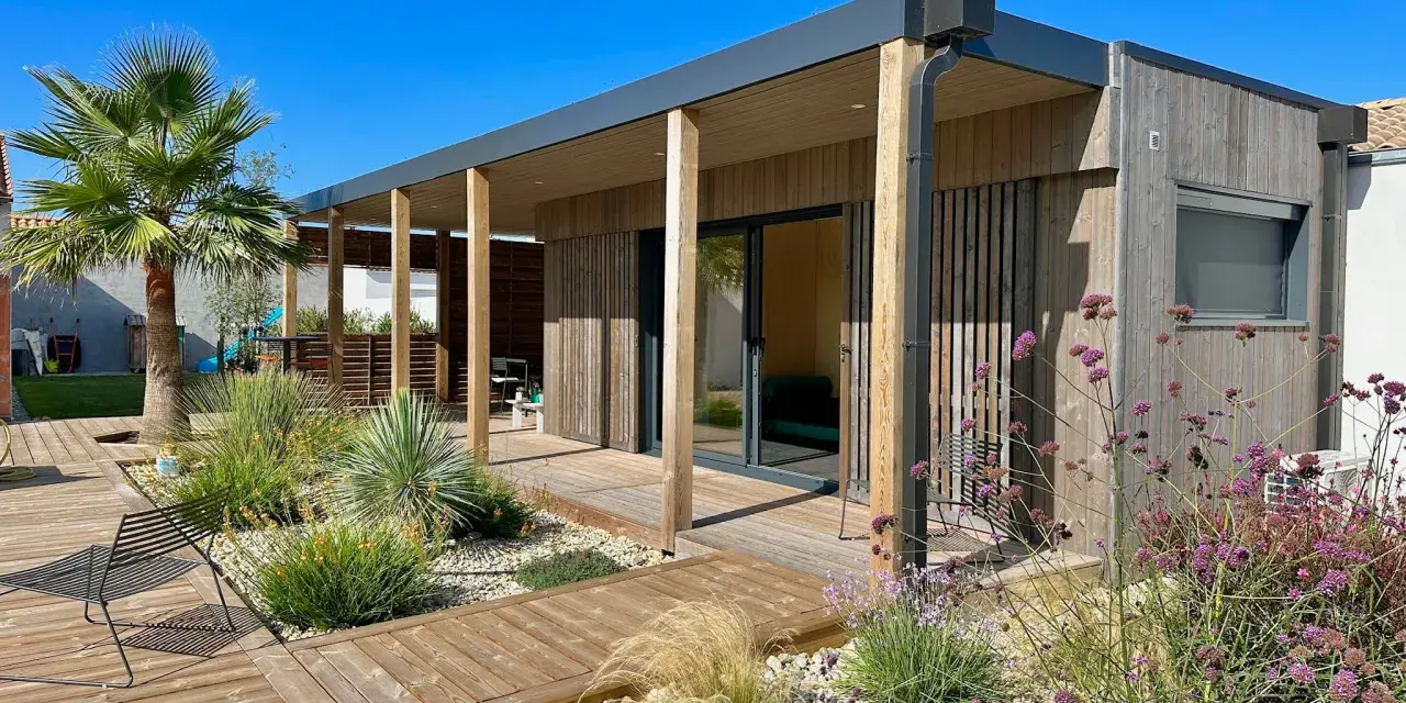 Une maison en bois moderne avec terrasse et jardin, une construction sans permis de construire idéale pour un espace de vie contemporain.