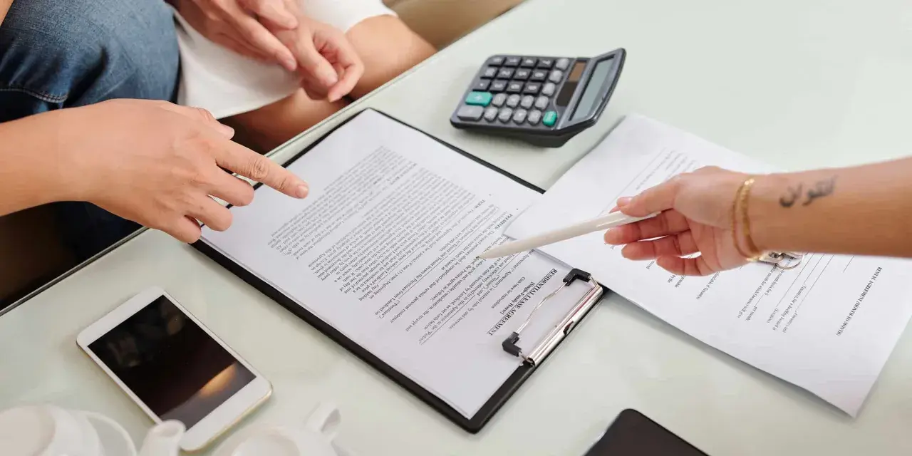Un bail signé par un seul indivisaire, avec un téléphone et une calculatrice sur la table.