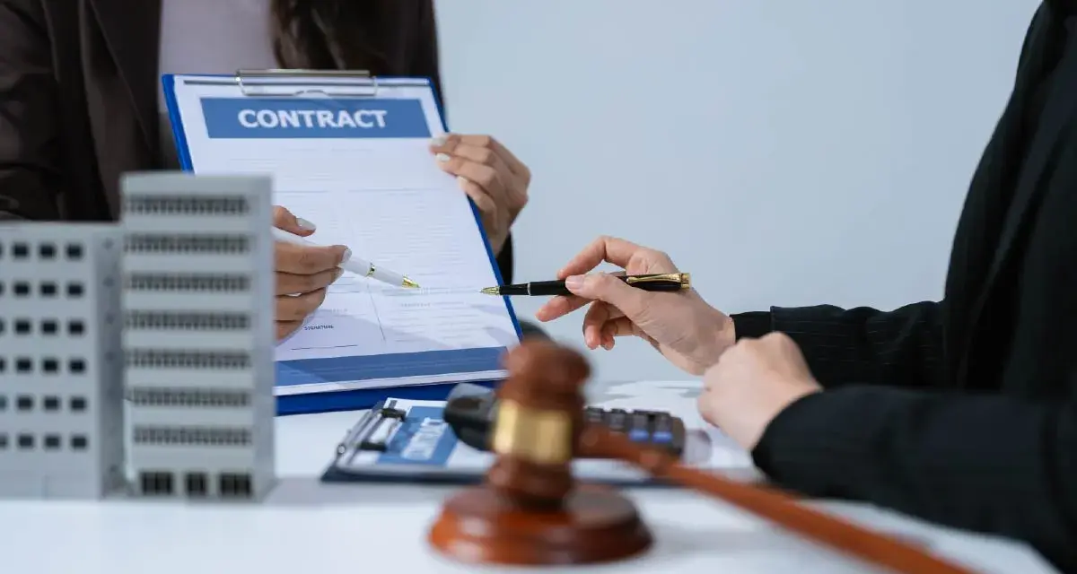 Deux mains signent un contrat immobilier, évoquant le droit de rétractation. Une maquette d'immeuble est visible.