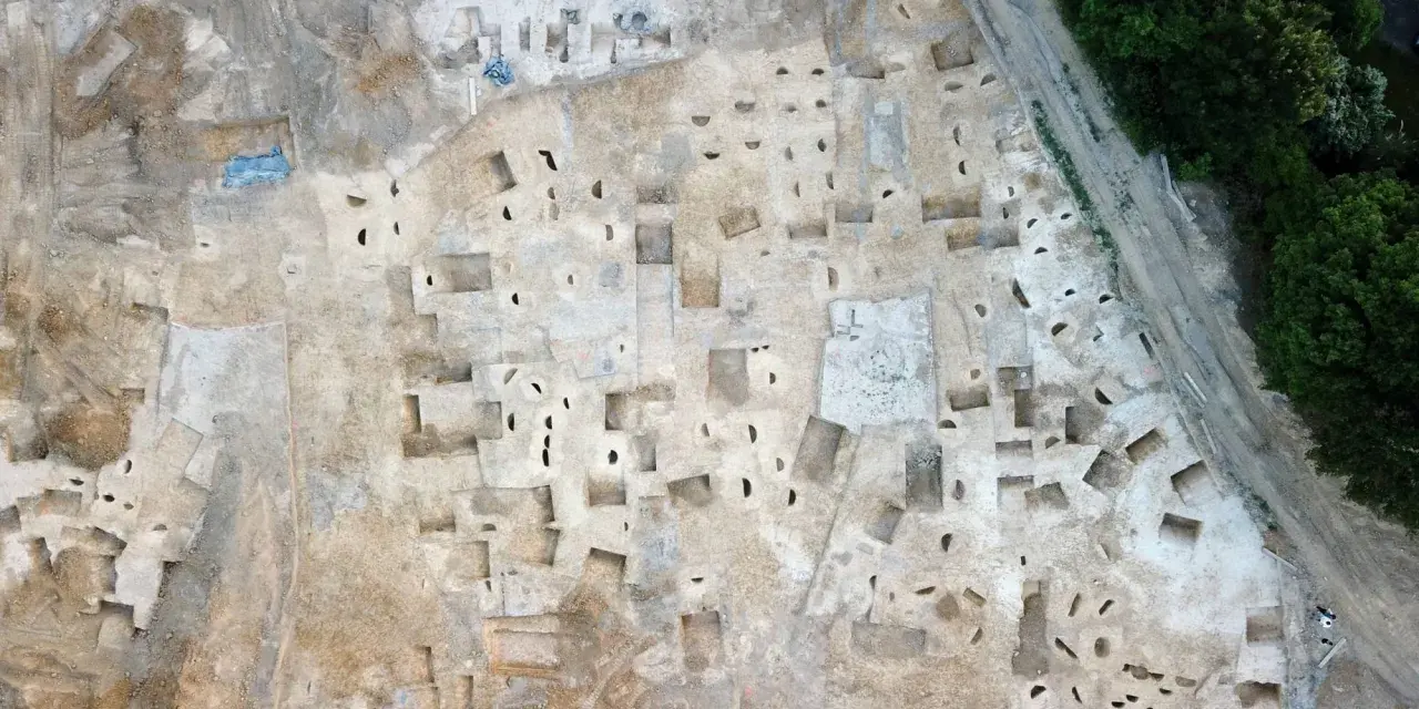 Vue aérienne d'un chantier de fouilles archéologiques à Plu Hasparren, révélant des structures et des trous de poteaux.