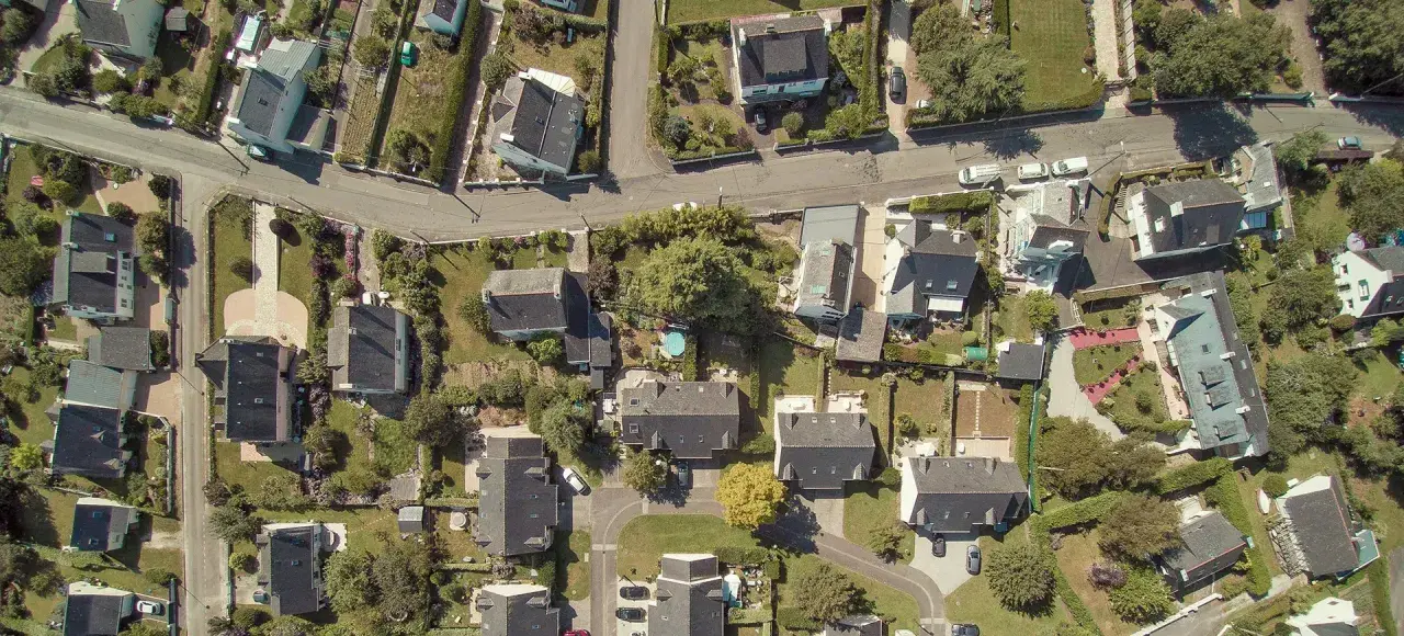 Vue aérienne d'un quartier résidentiel, avec des maisons aux toits sombres et des jardins verdoyants. Le cadastre noisy le sec révèle l'organisation des parcelles.