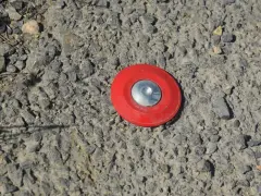 Borne rouge sur le sol, marquant un point pour le cadastre de Tarascon.