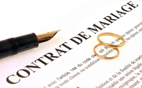Plume et alliances sur un contrat de mariage, symbolisant une union et une récompense travaux d'amélioration.
