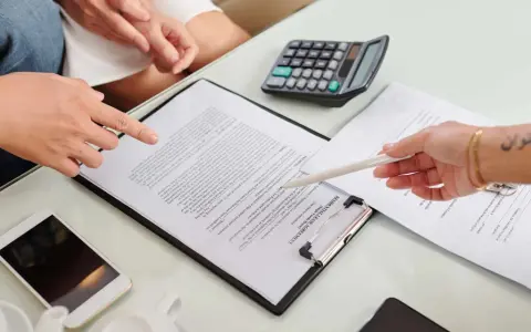 Un bail signé par un seul indivisaire, avec un téléphone et une calculatrice sur la table.