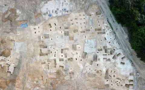 Vue aérienne d'un chantier de fouilles archéologiques à Plu Hasparren, révélant des structures et des trous de poteaux.