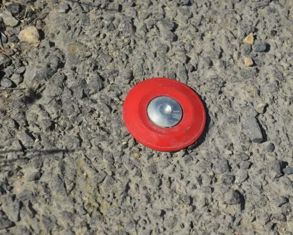 Borne rouge sur le sol, marquant un point pour le cadastre de Tarascon.