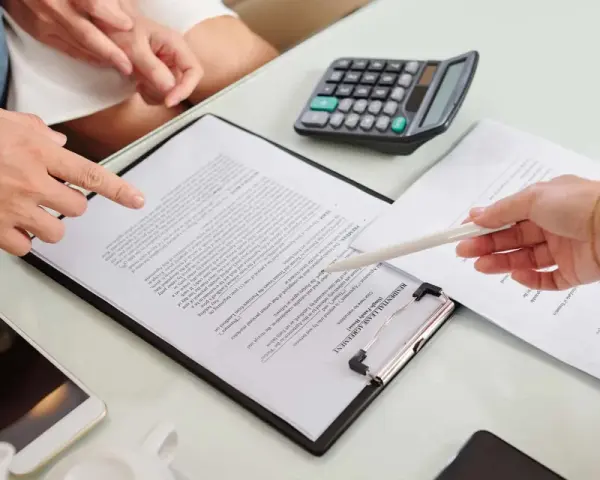 Un bail signé par un seul indivisaire, avec un téléphone et une calculatrice sur la table.