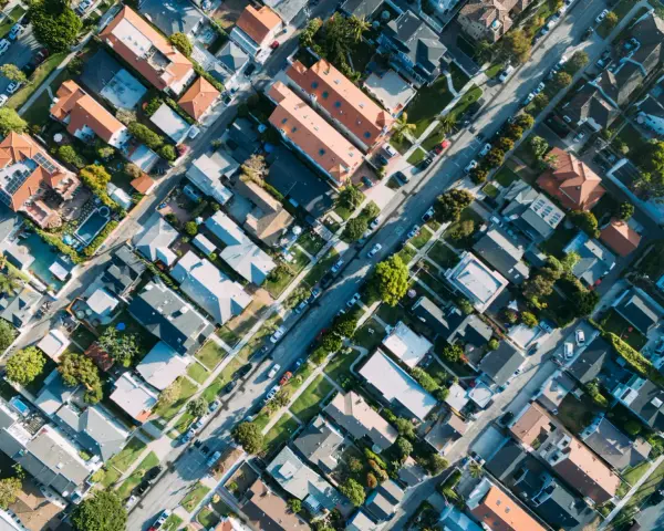 Vue aérienne d'un quartier résidentiel, avec des maisons aux toits de tuiles et des rues bordées d'arbres, rappelant l'application du l442-10 code urbanisme.