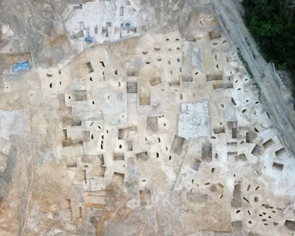 Vue aérienne d'un chantier de fouilles archéologiques à Plu Hasparren, révélant des structures et des trous de poteaux.