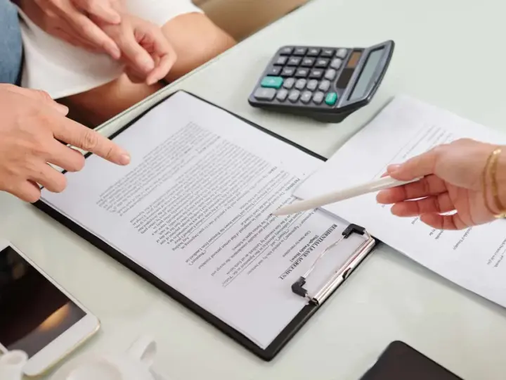 Un bail signé par un seul indivisaire, avec un téléphone et une calculatrice sur la table.