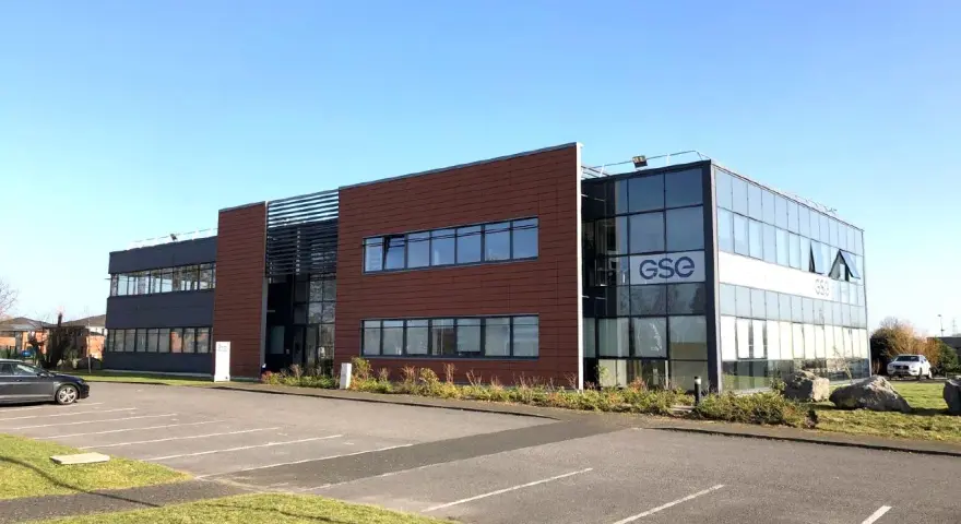 Bâtiment moderne avec façade vitrée et panneaux marron, arborant le logo GSE. Un parking est visible devant, près de Villeneuve d'Ascq.
