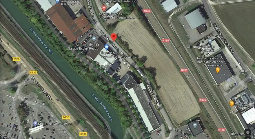 Vue aérienne de Bar-le-Duc : canal, route N135, bâtiments et terrains.