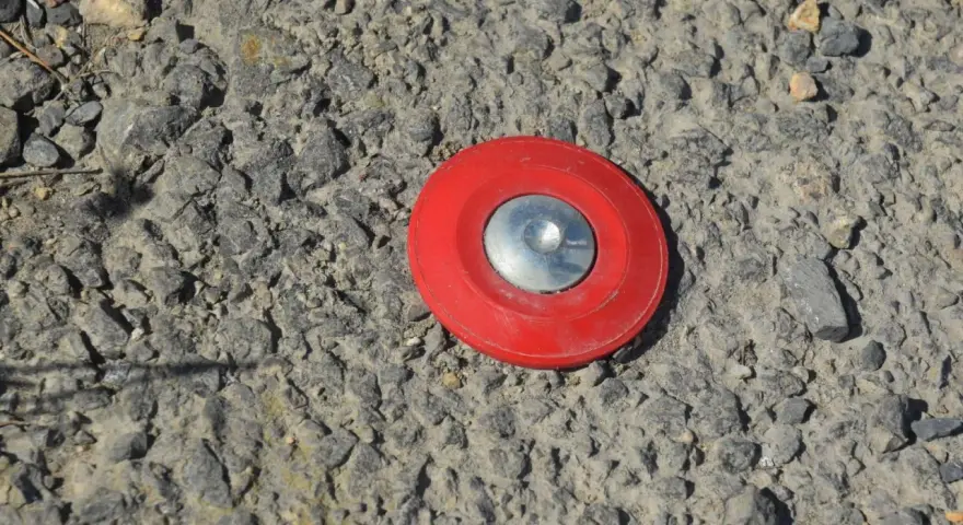 Borne rouge sur le sol, marquant un point pour le cadastre de Tarascon.