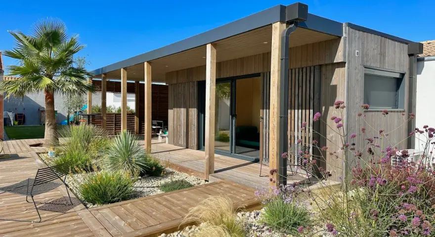 Une maison en bois moderne avec terrasse et jardin, une construction sans permis de construire idéale pour un espace de vie contemporain.
