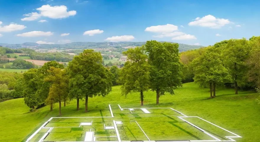 Plan d'une maison superposé sur un terrain verdoyant, illustrant la constructibilité d'un terrain. Paysage bucolique sous un ciel bleu.