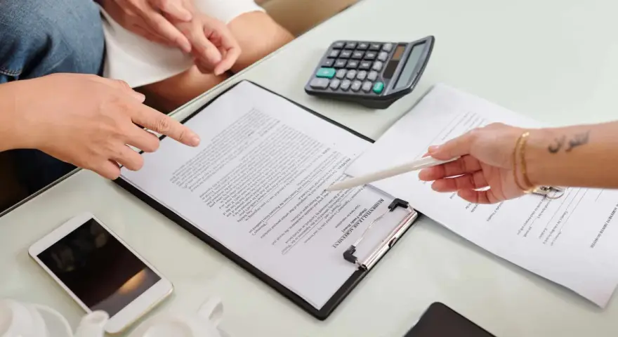 Un bail signé par un seul indivisaire, avec un téléphone et une calculatrice sur la table.
