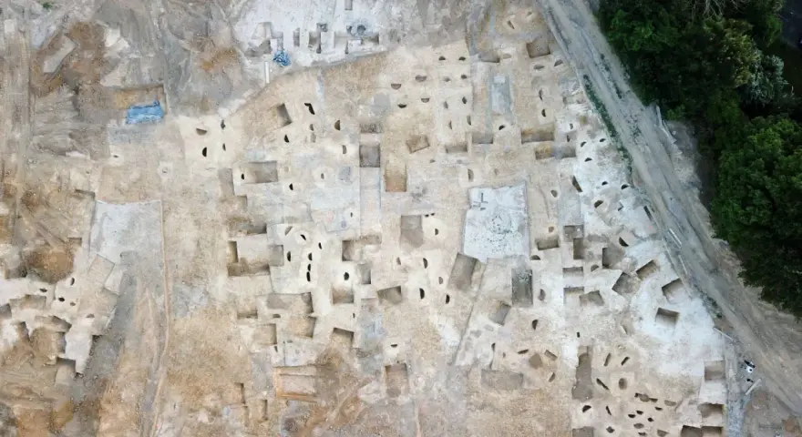 Vue aérienne d'un chantier de fouilles archéologiques à Plu Hasparren, révélant des structures et des trous de poteaux.