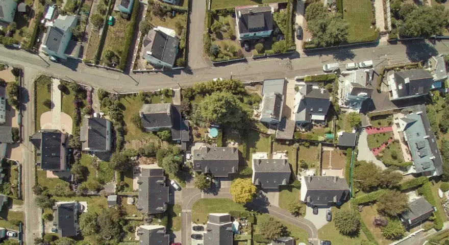 Vue aérienne d'un quartier résidentiel, avec des maisons aux toits sombres et des jardins verdoyants. Le cadastre noisy le sec révèle l'organisation des parcelles.