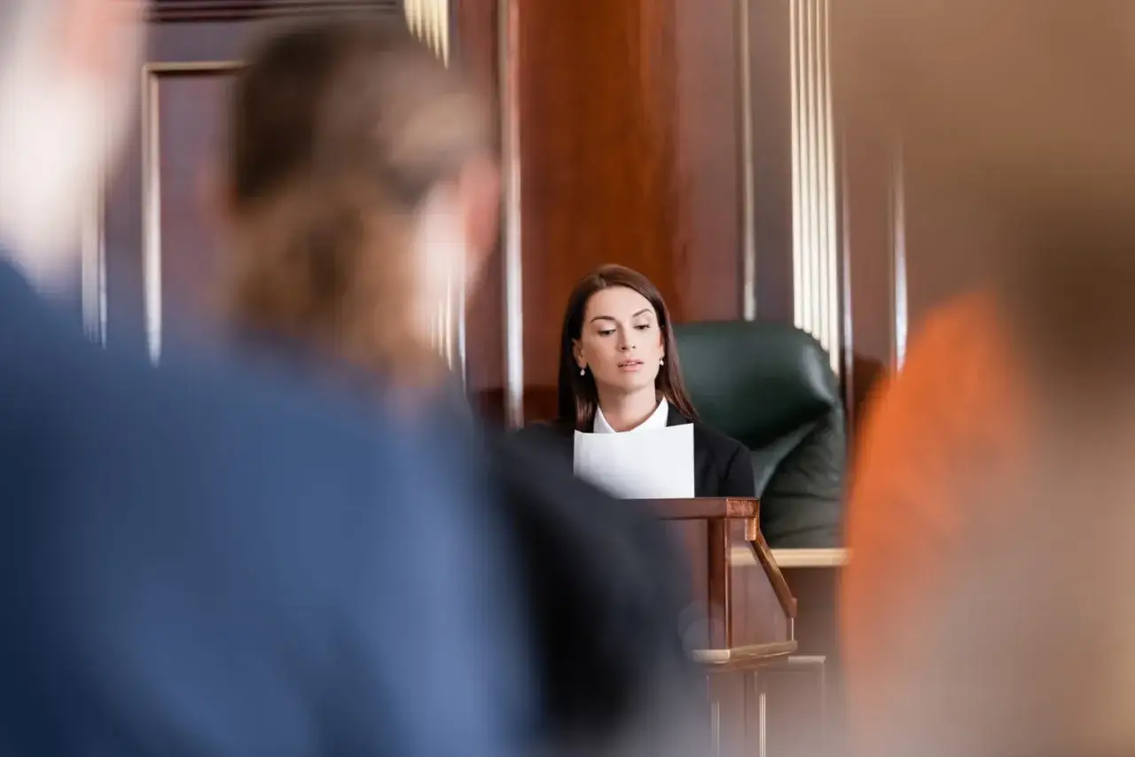 Une avocate présente son dossier, le dol, devant un juge. L'atmosphère est solennelle.