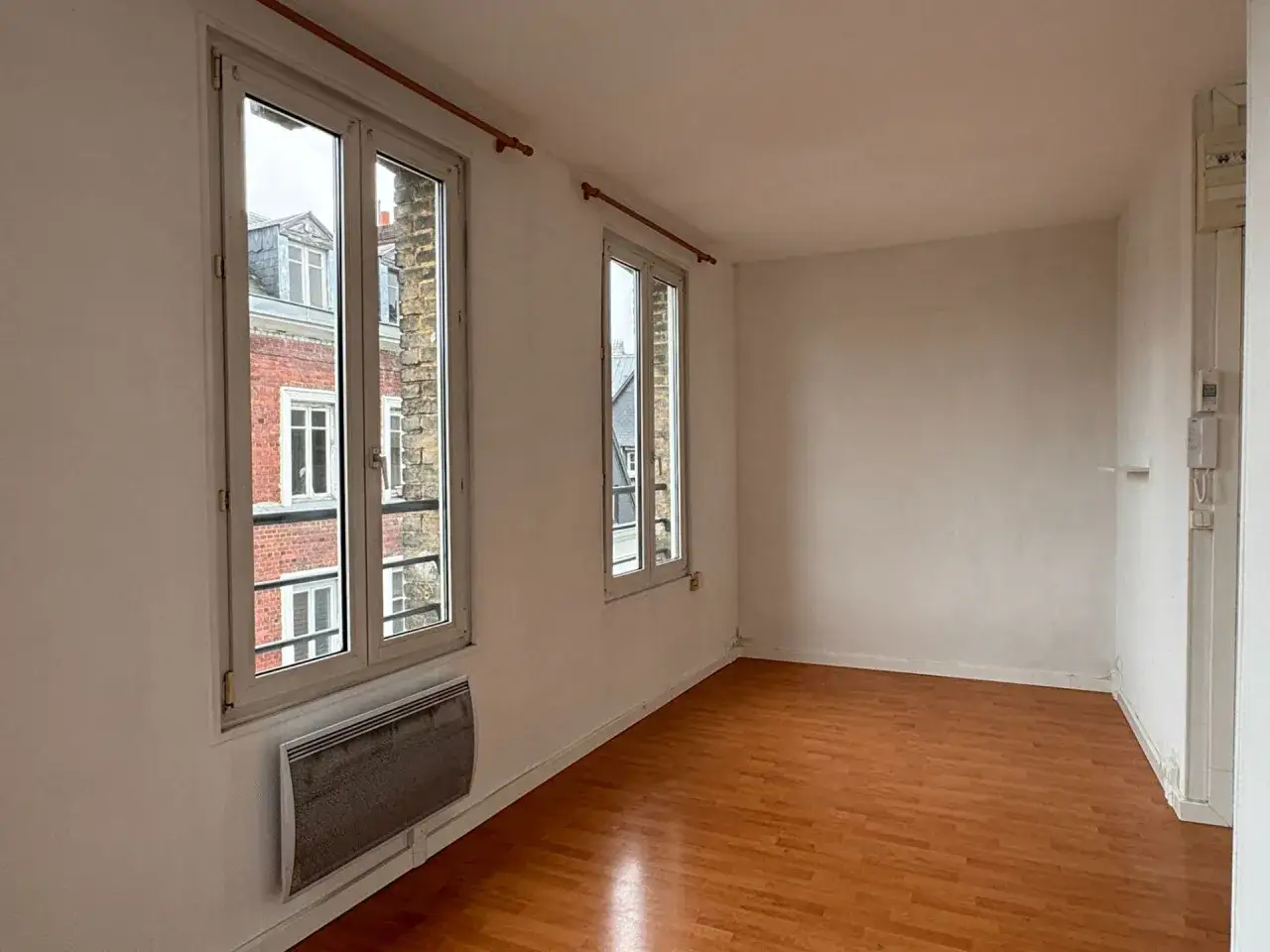 Pièce vide avec parquet, deux grandes fenêtres donnant sur des immeubles anciens. Le chauffage est inclus, que veut dire charges comprises ?