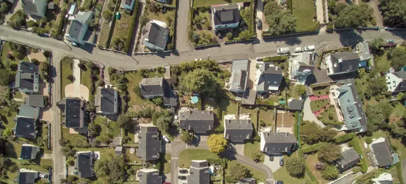 Vue aérienne d'un quartier résidentiel, avec des maisons aux toits sombres et des jardins verdoyants. Le cadastre noisy le sec révèle l'organisation des parcelles.